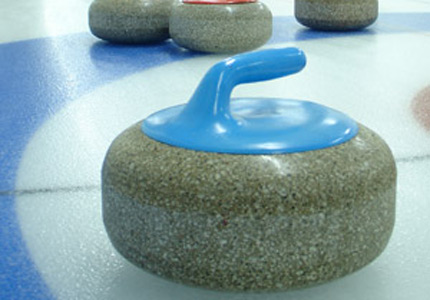 Kamień do curlingu stojący na lodzie.